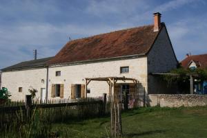 an old white building with a brown roof at Le gîte de la roche in Antigny