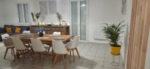 a dining room with a table and white chairs at Maison familiale tout équipée in Dunes
