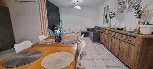 a kitchen and dining room with a wooden table at Maison familiale tout équipée in Dunes