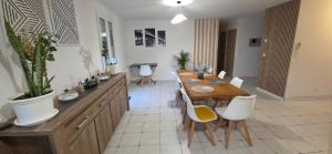 a dining room with a table and white chairs at Maison familiale tout équipée in Dunes