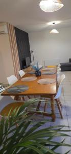 a long wooden table with white chairs and a plant at Maison familiale tout équipée in Dunes