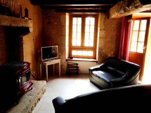 a living room with a couch and a tv at Le moulin de preuillé in Valence en Poitoux