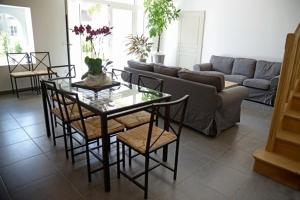 a living room with a couch and a table and chairs at Gîte de la tonnelle in Saint-Georges-lès-Baillargeaux
