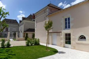 a large white house with a tree in the yard at Gîte de la tonnelle in Saint-Georges-lès-Baillargeaux