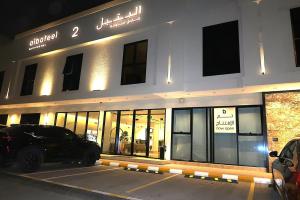 a building with a car parked in a parking lot at Albateel 2 Serviced Apartments-اقتصادي in Riyadh