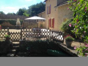 a garden with a fence and an umbrella at Le moulin de preuillé in Valence en Poitoux +10 photos