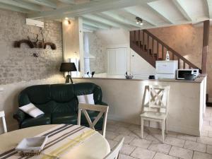 a living room with a green couch and a table at L'althéa in Saint-Gervais-les-Trois-Clochers