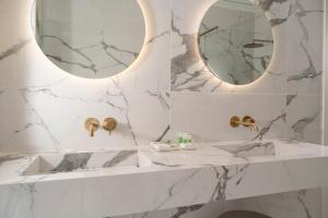 a white marble bathroom with a mirror and a sink at Just Hotel Saronno in Saronno