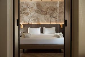 a bed with white sheets and pillows in a room at Just Hotel Saronno in Saronno