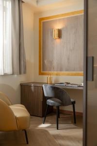 a living room with a chair and a desk at Just Hotel Saronno in Saronno
