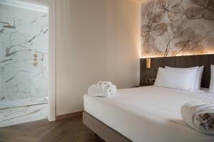 a bedroom with a white bed and a window at Just Hotel Saronno in Saronno