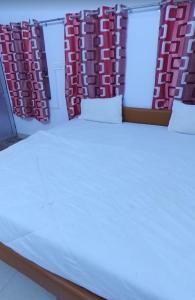 a bed in a room with red and white curtains at Hotelthemarwarexcellency in Jodhpur
