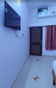 a room with a door and a television and a room with at Hotelthemarwarexcellency in Jodhpur