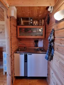 a kitchen with a sink and a stove in a cabin at Kaggestorps Gård in Hjo