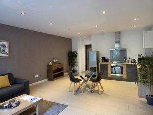 a living room with a couch and a table at HPC Suites - Cassis Centre - Parking Securisé et Piscine Chauffée in Cassis