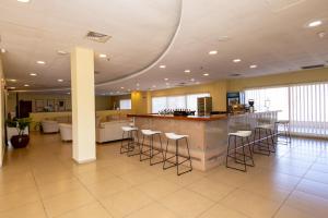 a lobby with a bar and some bar stools at Almar Aparthotel in Lobito