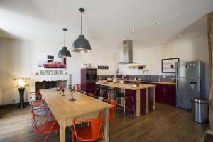 a kitchen with tables and chairs and a kitchen with a stove at Le clos mélior in Lusignan