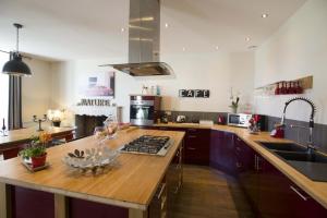 a kitchen with a wooden counter top and a sink at Le clos mélior in Lusignan +5 photos