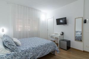 a bedroom with a bed and a desk and a television at Joseph's House Accommodation in Civitavecchia