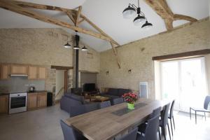 a kitchen and living room with a table and chairs at Les pierres de la dive in Valence en Poitoux +5 photos