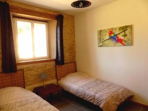 a bedroom with two beds and a window at Les pierres de la dive in Valence en Poitoux