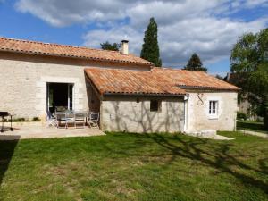 an external view of a stone house with a patio at Les pierres de la dive in Valence en Poitoux