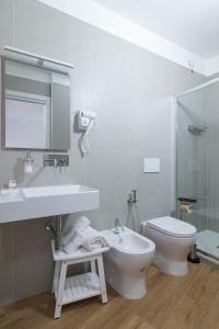 a white bathroom with a sink and a toilet at Joseph's House Accommodation in Civitavecchia +22 photos