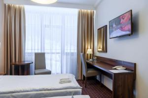 a hotel room with a desk and a bed at Hotel Podium in Wisła +82 photos