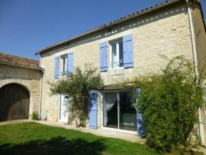 a large brick building with blue shutters on it at Le clos constance in Yversay
