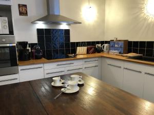 a kitchen with two cups and saucers on a wooden table at Le clos constance in Yversay