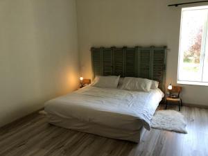 a bedroom with a large bed with white sheets and pillows at Le clos constance in Yversay