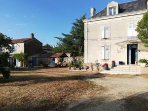 an old white house with a yard at Le clos constance in Yversay