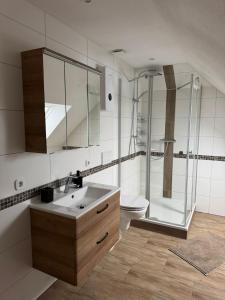 a bathroom with a sink and a shower and a toilet at Hotel Restaurant 7 Berge am Schlehberg in Alfeld +79 photos