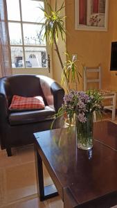 a living room with a couch and a table with flowers at Les saules in Persac
