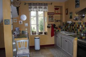 a kitchen with a counter and a sink and a window at Les saules in Persac