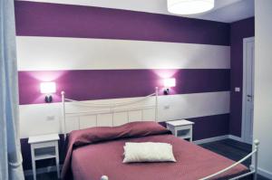 una camera da letto viola e bianca con un letto e due lampade di Casa Remussi a Treiso
