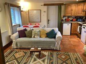 a living room with a couch and a kitchen at Hops and the Vines in Shipston-on-Stour