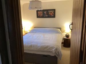 a bedroom with a white bed with two lamps at Hops and the Vines in Shipston-on-Stour