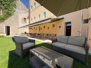 a patio with a couch and chairs and an umbrella at Palazzo Contelori in Terni