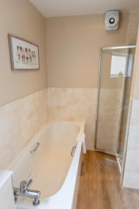 a white bath tub in a bathroom with a shower at Bachilton Farm Holidays in Perth +66 photos