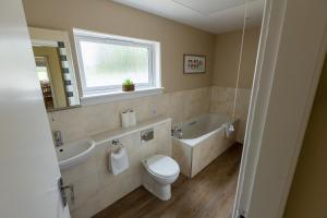 a bathroom with a toilet and a tub and a sink at Bachilton Farm Holidays in Perth