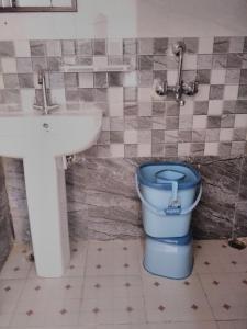 a bathroom with a blue toilet and a sink at Mount aura stay & Dine in Kanatal