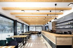 a restaurant with wooden ceilings and tables and chairs at Vila Eduarda Grohmanna in Vrbno pod Pradědem