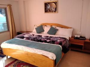 a bedroom with a large wooden bed with pillows at Mount aura stay & Dine in Kanatal