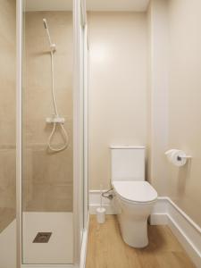 a bathroom with a toilet and a shower at Hostal Pico de Noro in Ribeira