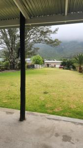 a large field of grass with a house in the background at Boschberg Accommodation in Somerset East
