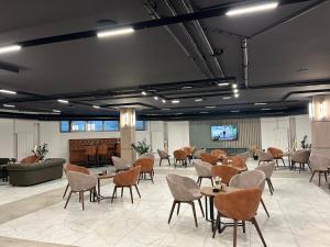 a large room with tables and chairs and a piano at Hotel Radan Prolom Banja in Prolomska Banja
