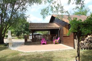 two pink chairs sitting outside of a cabin at Le chalet des forges in Mairé