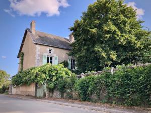 a brick house with a tree in front of a street at Les tilleuls in Persac