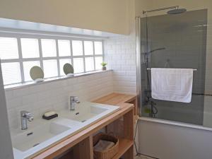 a bathroom with a white sink and a shower at Les tilleuls in Persac